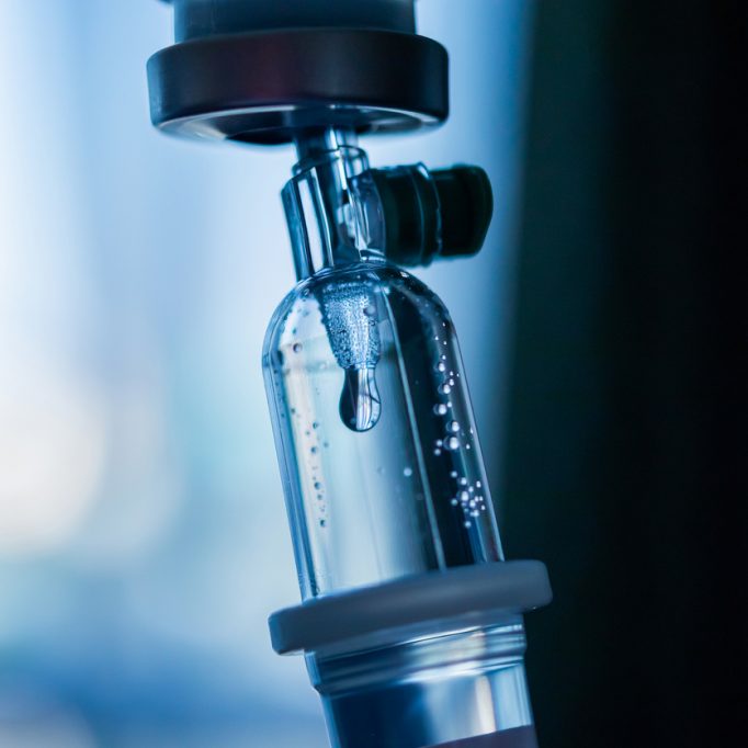 Close up medical intravenous IV drip in hospital background