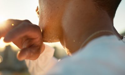Chin, hand and sweating with sports person outdoor in nature closeup for exercise or fitness. Cardio, challenge and intense with athlete wiping perspiration from skin for marathon training or workout